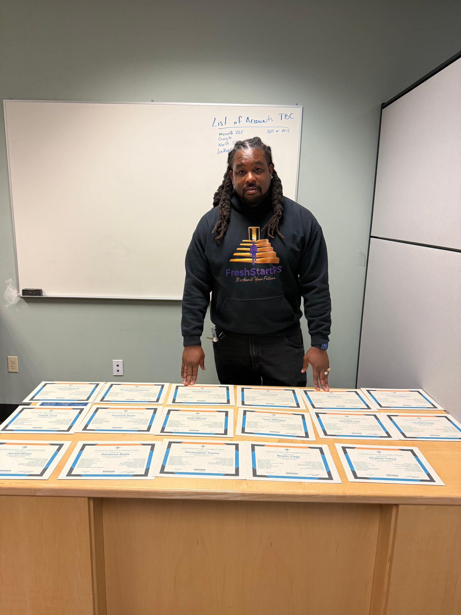 Jerrel Jones with completion certificates for graduating students